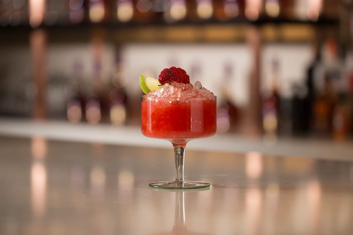red valentine's day cocktail with raspberry garnish
