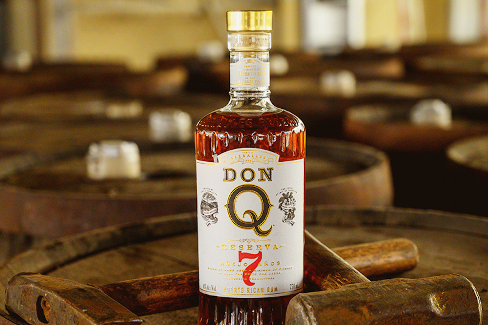 Don Q Reserva 7 rum bottle on an oak barrel