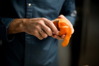 man peeling an orange