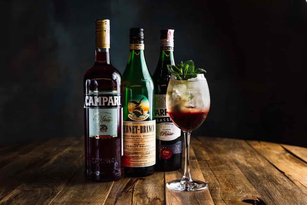 Campari and Fernet-Branca cocktail in a wine glass with mint garnish