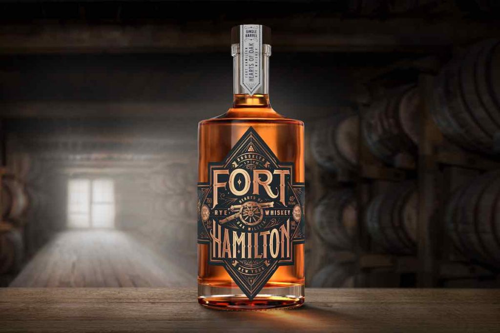 Fort Hamilton rye whiskey bottle in front of barrels