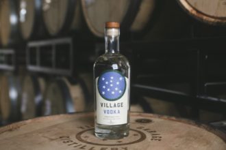Village Vodka bottle on a barrel