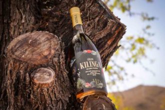 a bottle of kilinga bacanora nestled on a tree