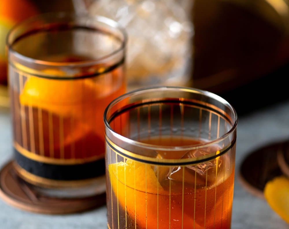 two glasses of Maple Butter Old Fashioned with orange peel garnishes