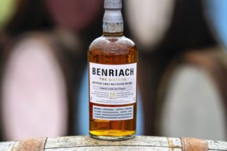 Benriach the Sixteen whisky bottle on a barrel