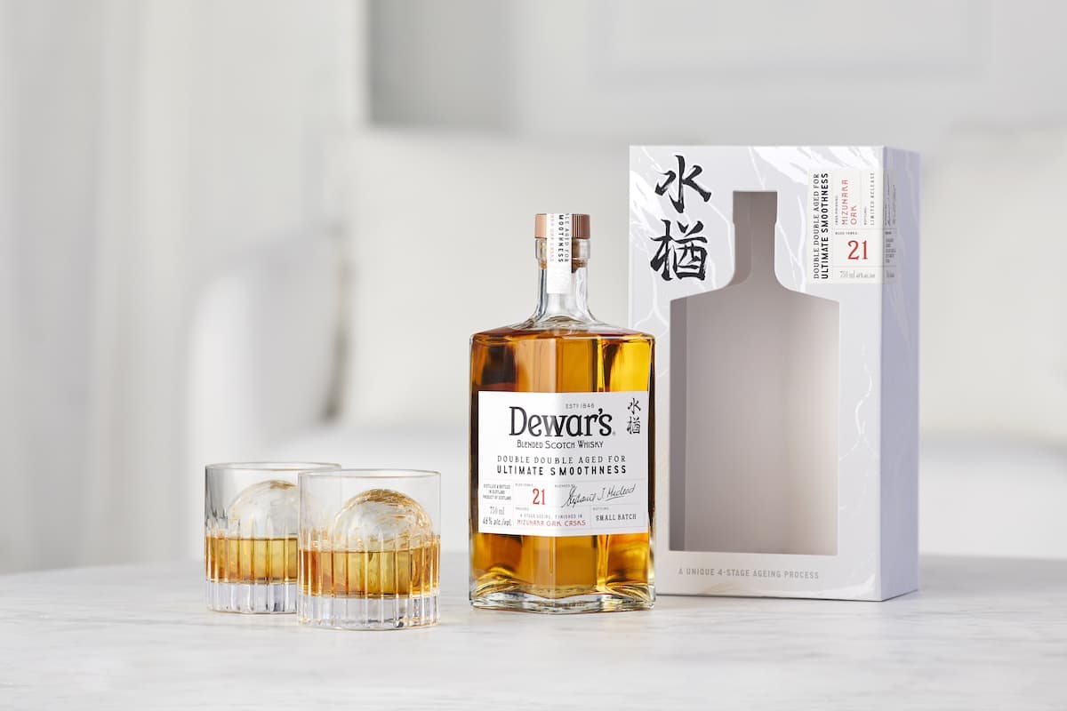 A bottle of Dewars Double Double 21 Year Mizunara Whisky with two glasses