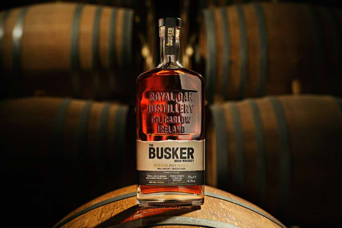 bottle of the busker small batch single pot still whiskey on top of a barrel