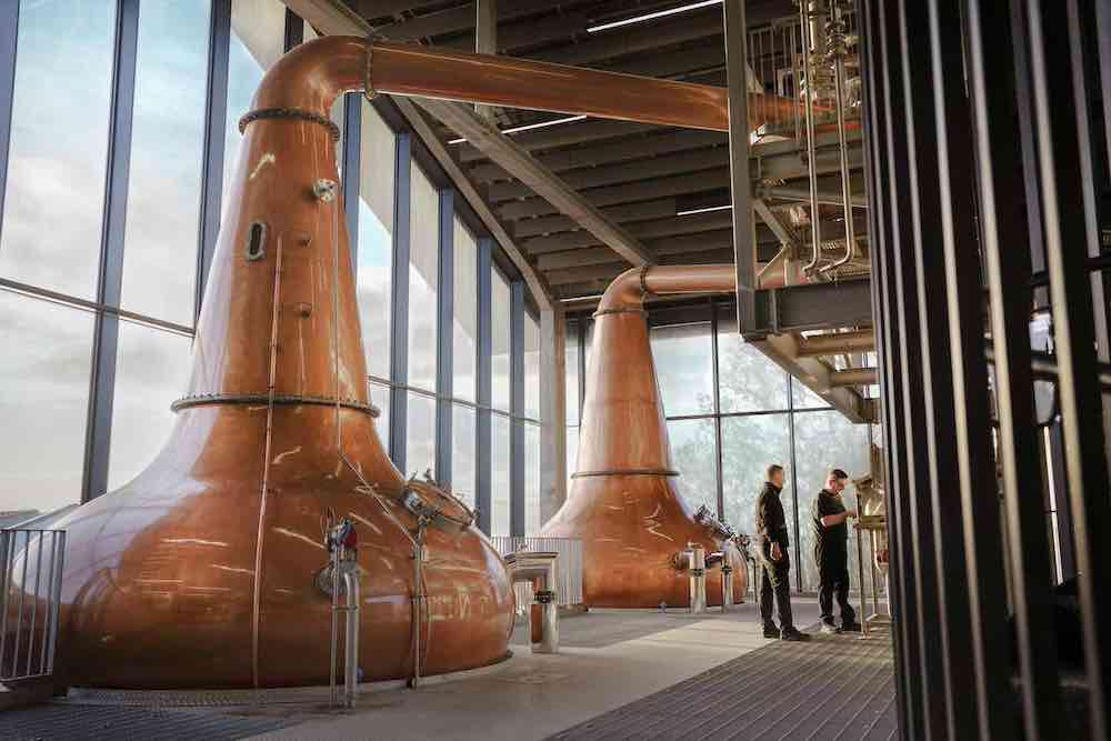 Two copper stills and distillery workers Inside Port Ellen Distillery